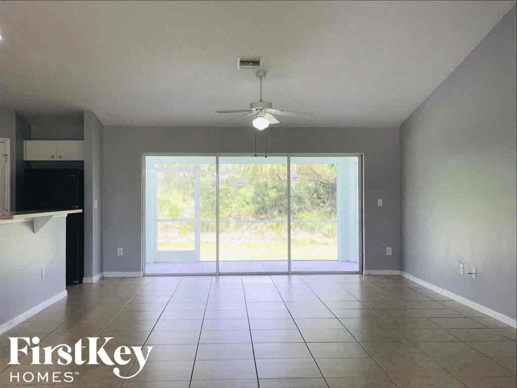A spacious room with a sliding glass door leading to a garden.