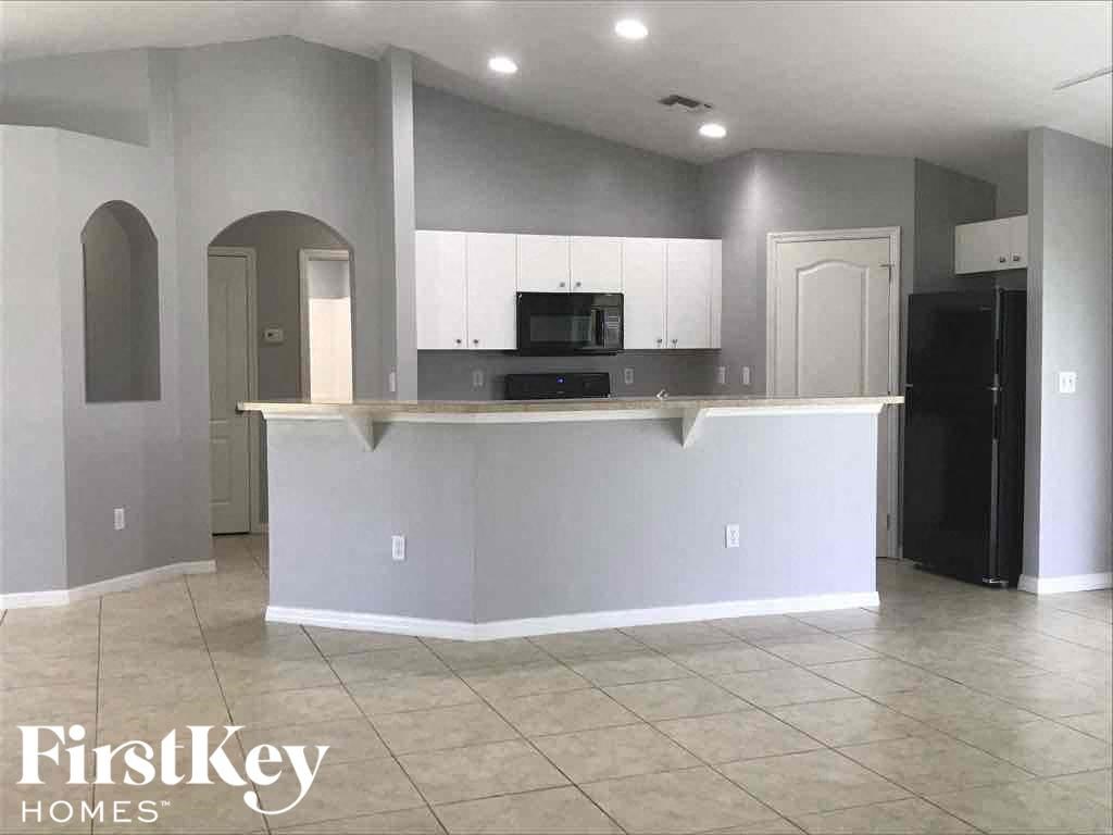 A kitchen with a counter and a fridge.