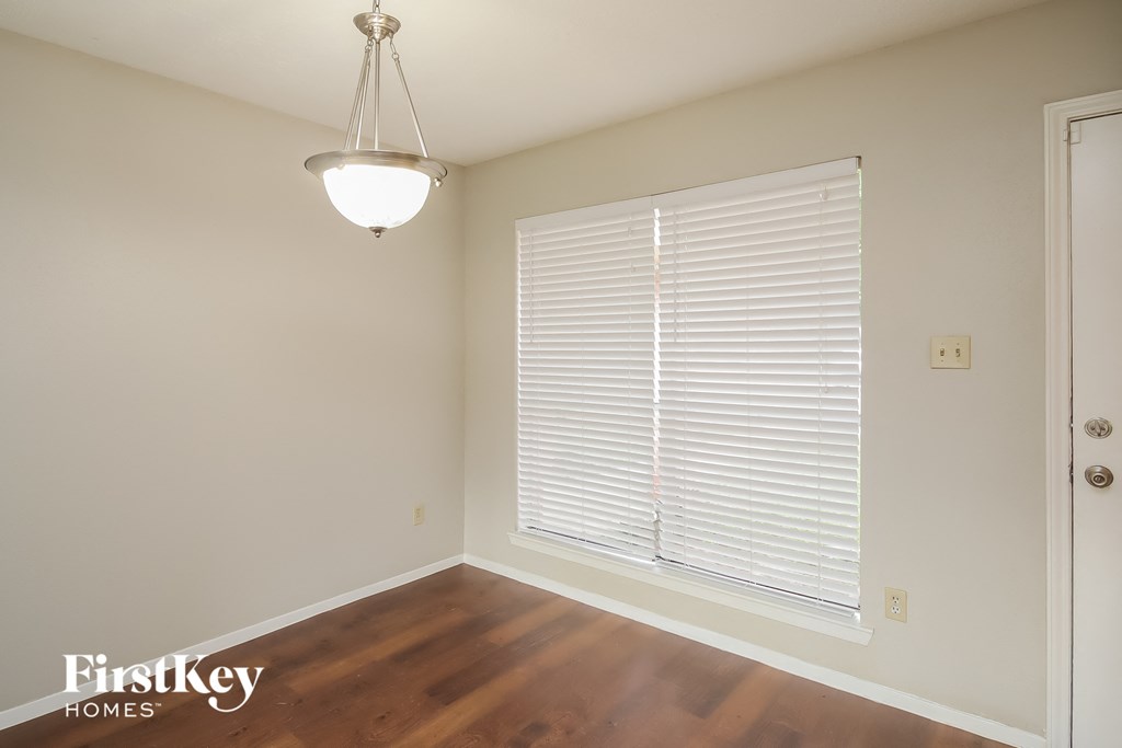 a living room with a large window and wood flooring