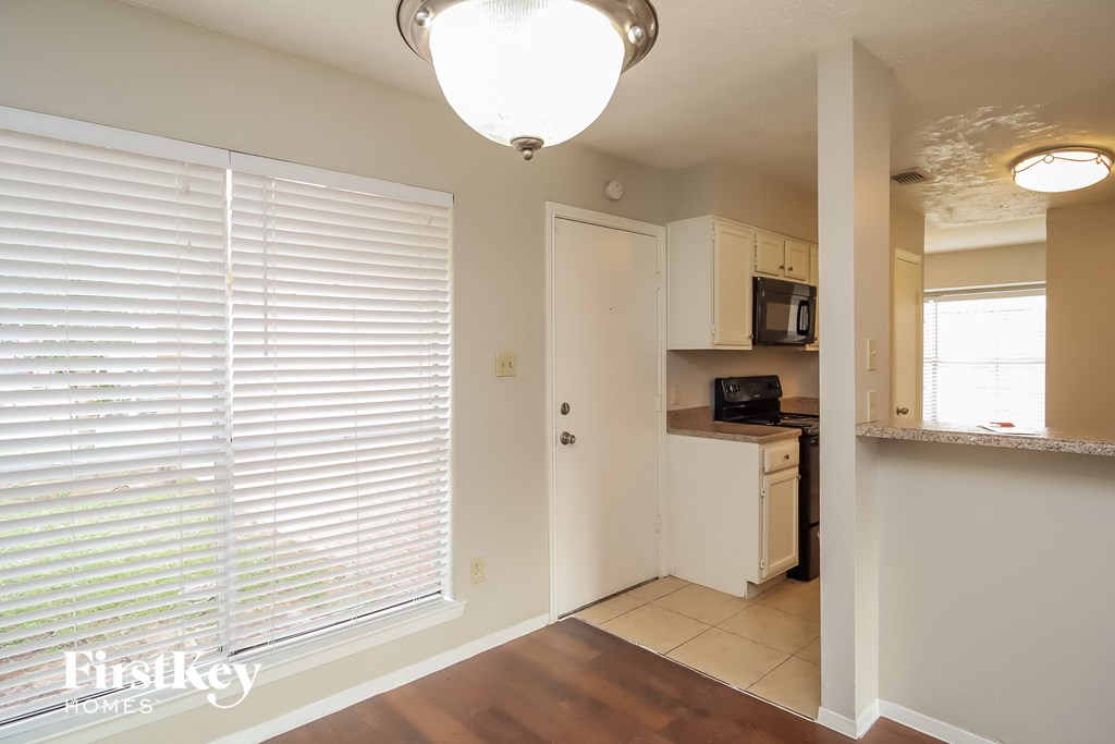 an empty kitchen with a large window and a door to the bathroom