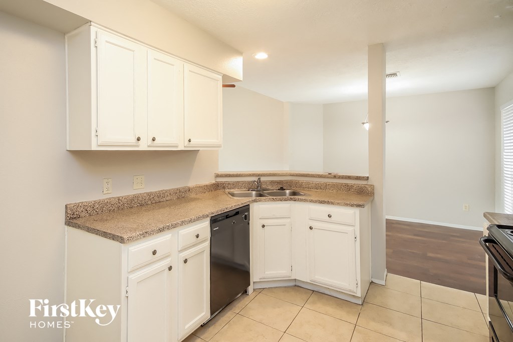 a kitchen with white cabinets and granite counter tops