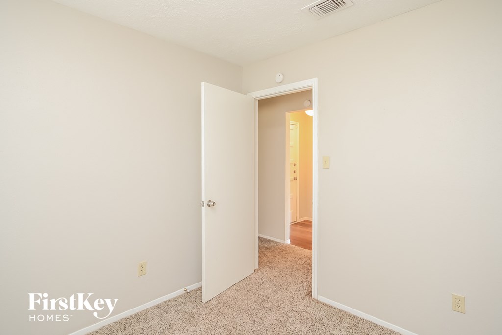 a bedroom with an open door and a hallway to a closet