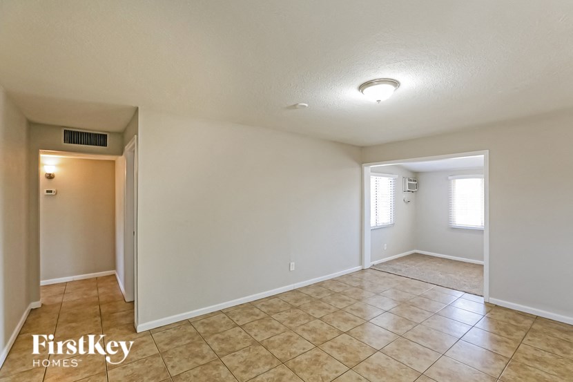 the spacious living room and dining room with tile flooring