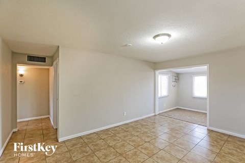 the spacious living room and dining room with tile flooring