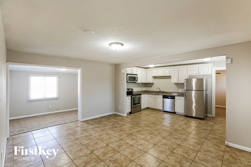 an empty kitchen with stainless steel appliances and tile flooring