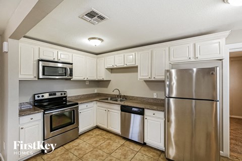 a kitchen with stainless steel appliances and white cabinets