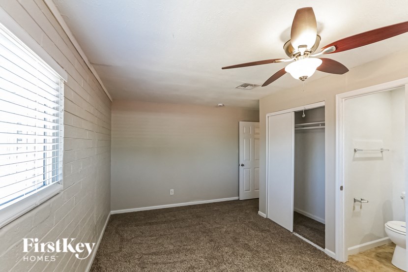 a bathroom with a ceiling fan and a closet