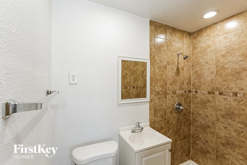 a bathroom with a toilet and a shower and a sink
