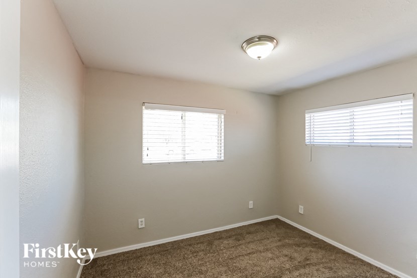 a bedroom with a carpeted floor and a window