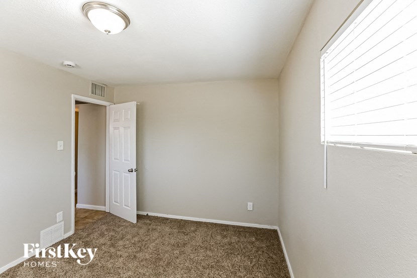 a bedroom with a door to a closet and a window