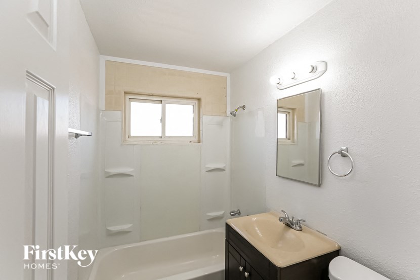 a white bathroom with a sink and a shower