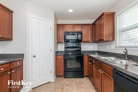 A kitchen with brown cabinets and black appliances.