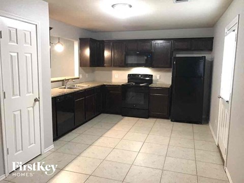 A kitchen with black cabinets and appliances is for sale.