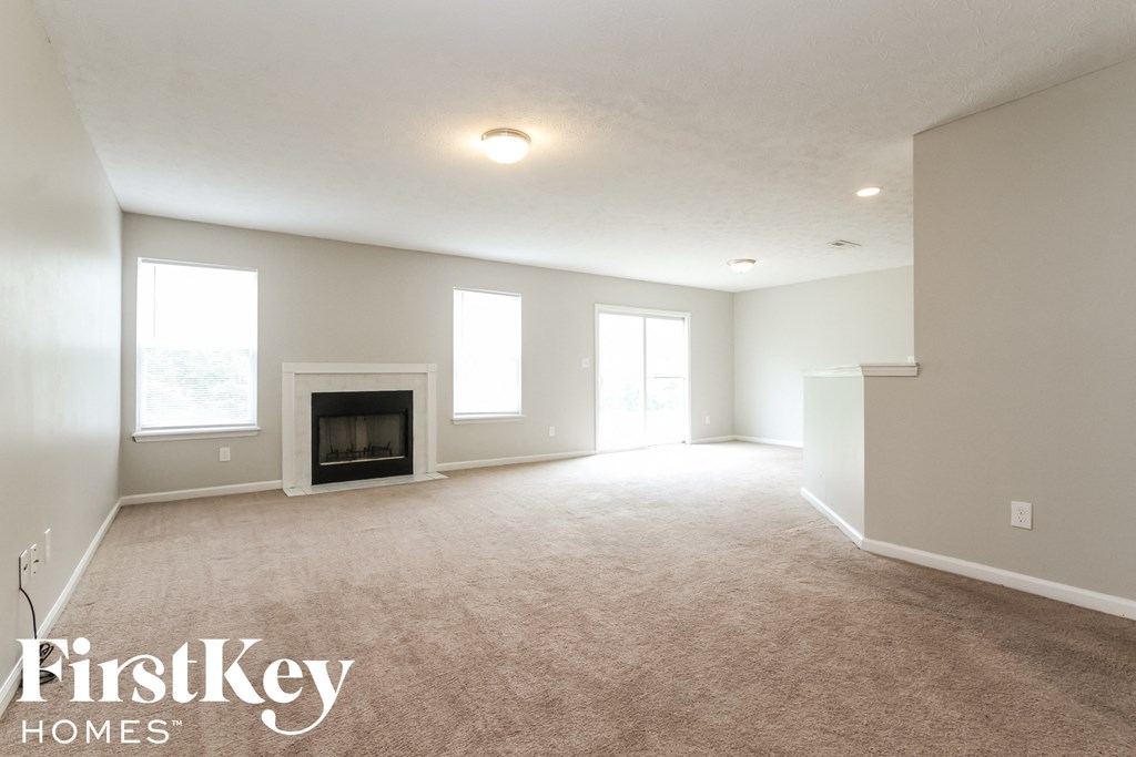 the living room of an empty house with a fireplace