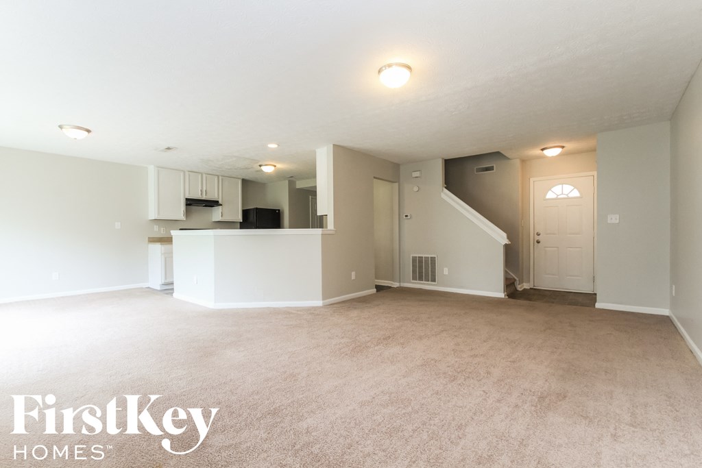 the living room and kitchen of an empty house