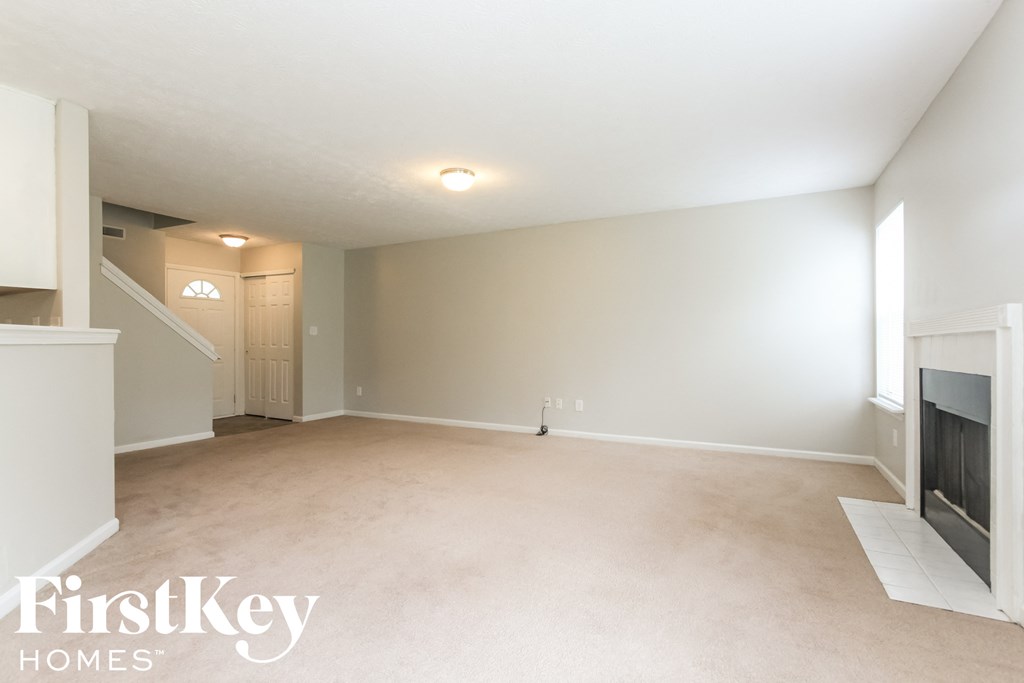 a living room with a fireplace and a carpeted floor