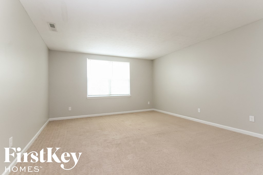 a bedroom with a carpeted floor and a window