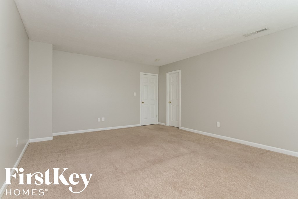 a bedroom with a carpeted floor and a white door