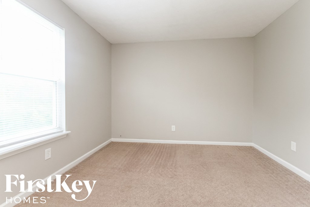 a bedroom with a carpeted floor and a large window