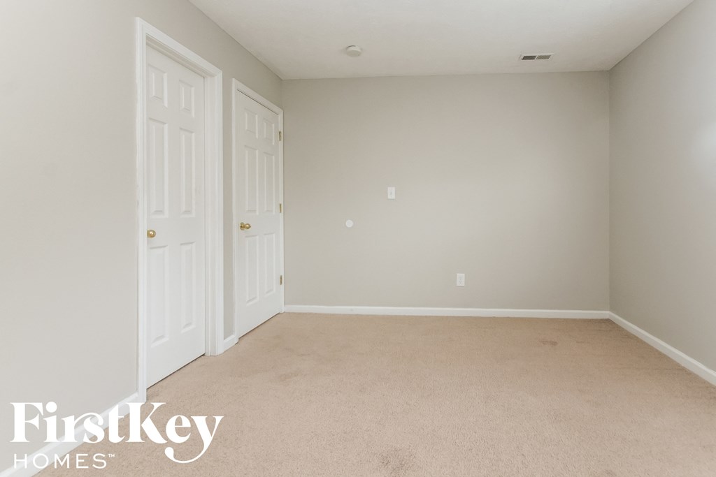 a bedroom with two closets and a carpeted floor