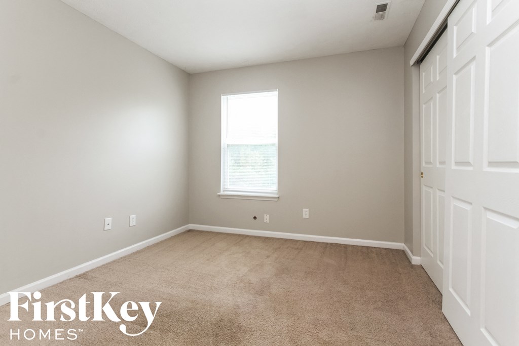 a bedroom with a carpeted floor and a window