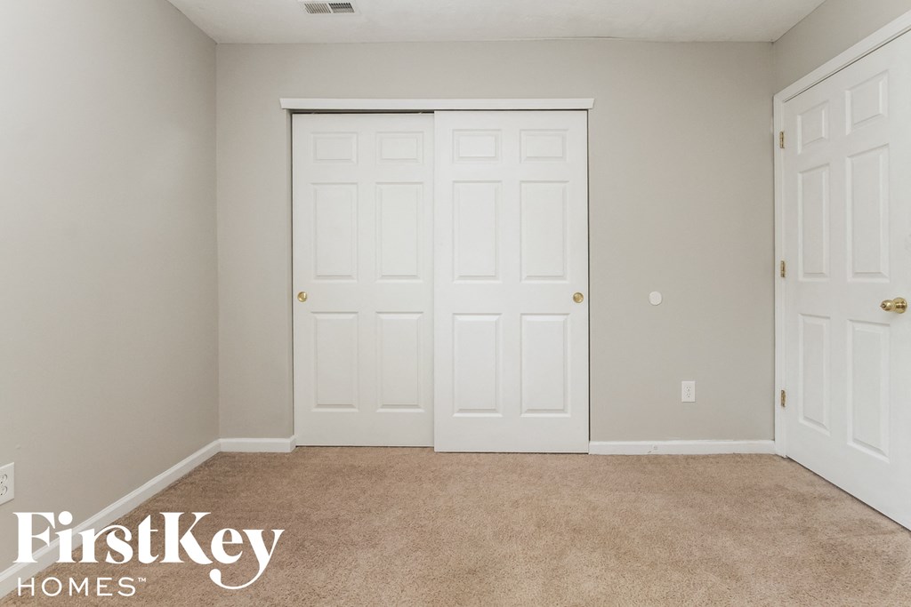 a bedroom with two closets and two doors