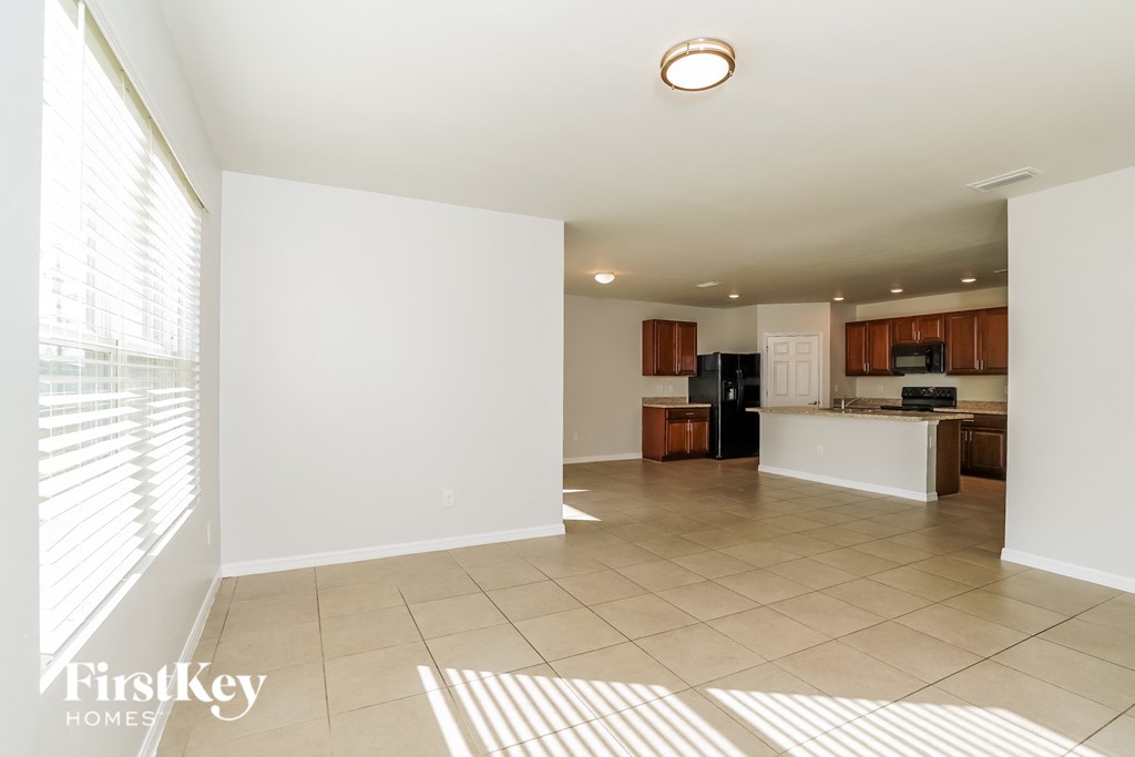an empty living room and kitchen with a large window