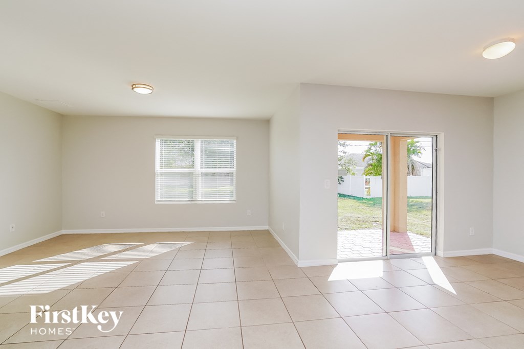 an empty living room with a sliding glass door to the yard