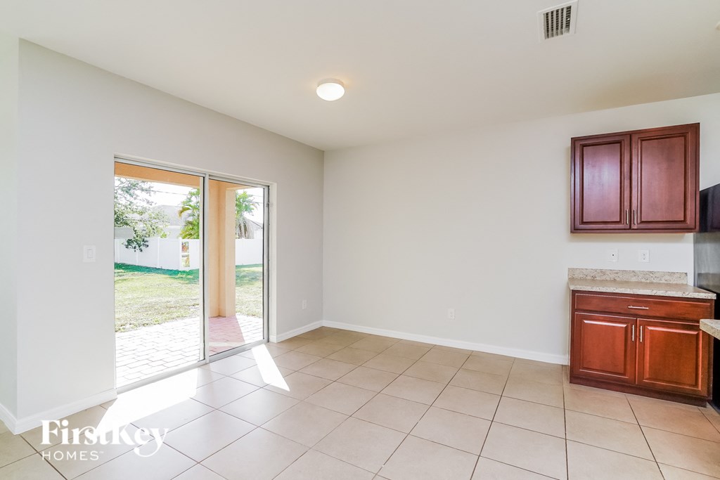 a living room with a door to the yard and a kitchen