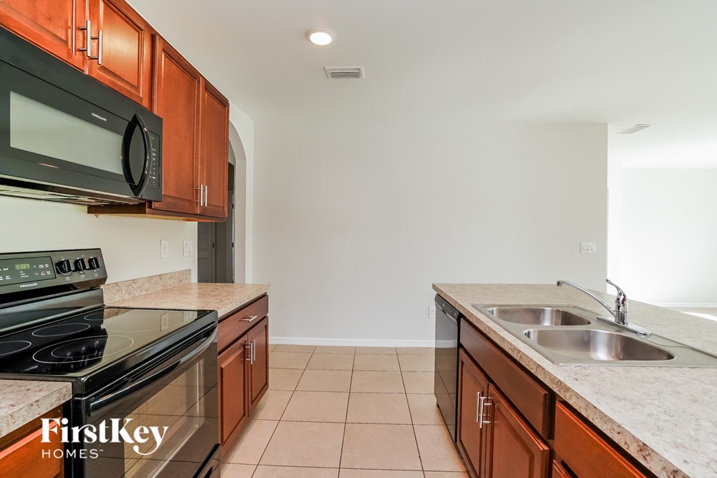 a kitchen with wood cabinets and black appliances and a sink