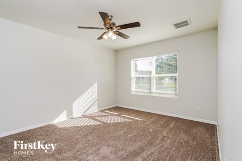 a living room with carpet and a ceiling fan