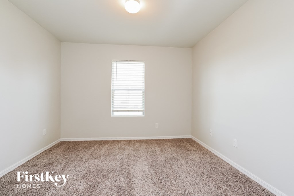 a spacious room with carpet and a window