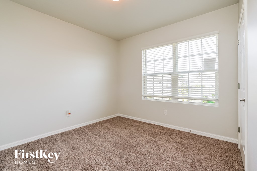 a bedroom with a carpeted floor and a window