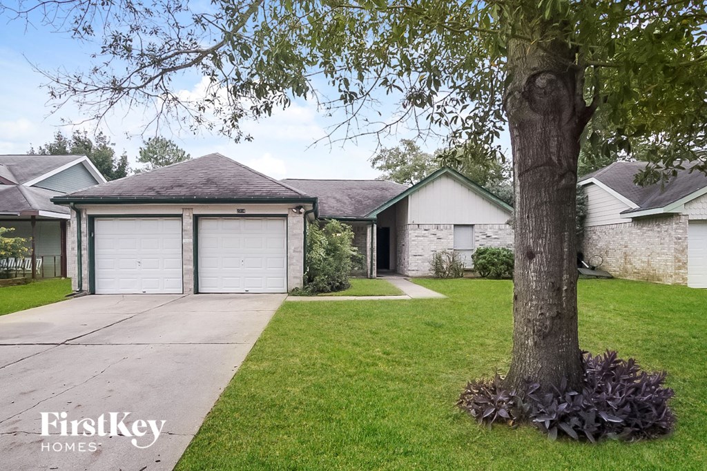 a house with a garage and a tree in the yard