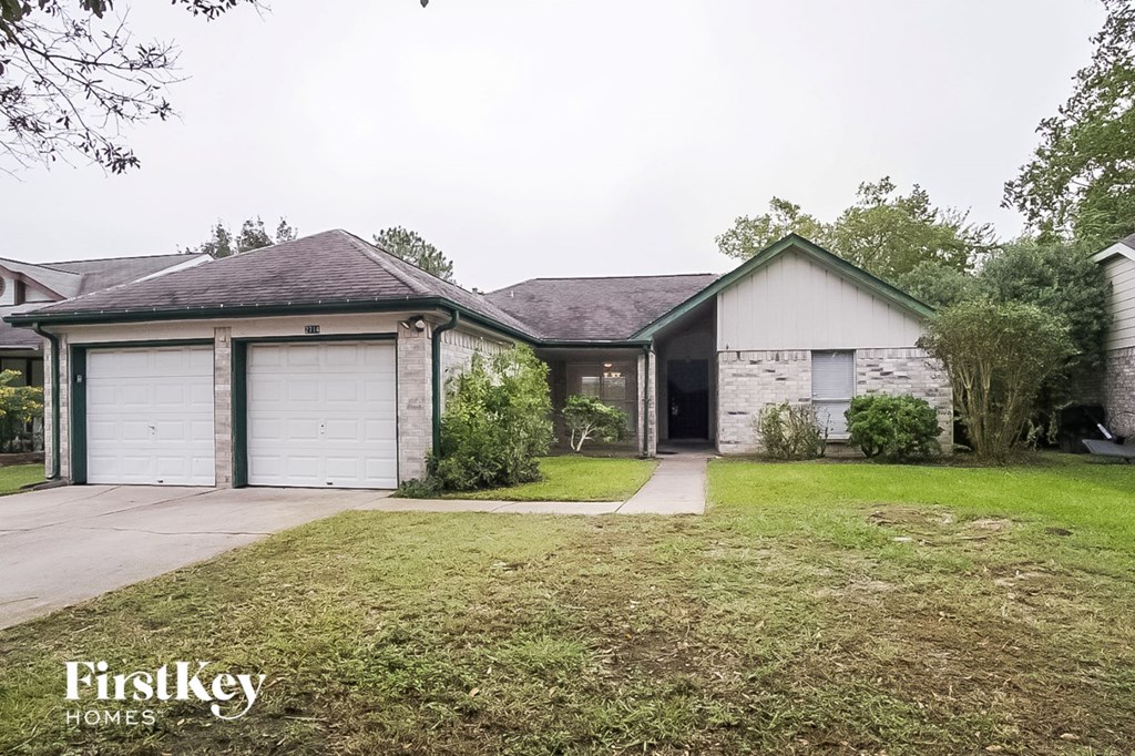 a house with two garage doors and a lawn in front of it