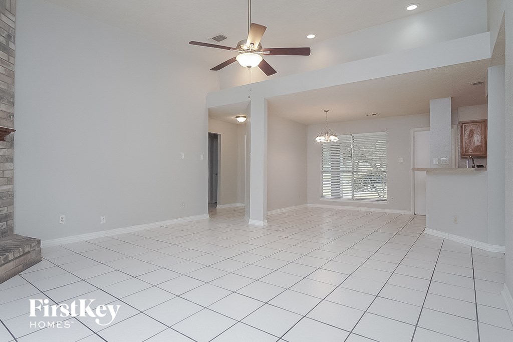 an empty kitchen and living room with a ceiling fan