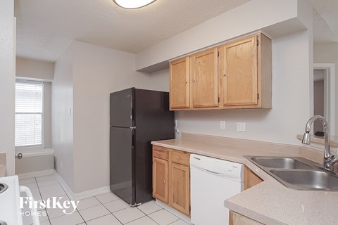 a kitchen with wooden cabinets and a black refrigerator