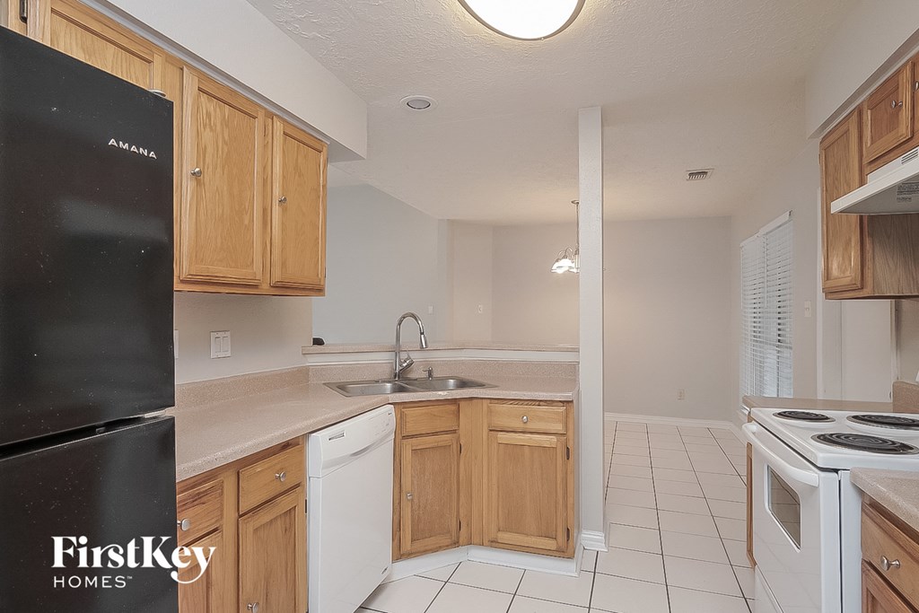 a kitchen with wooden cabinets and white appliances and a sink