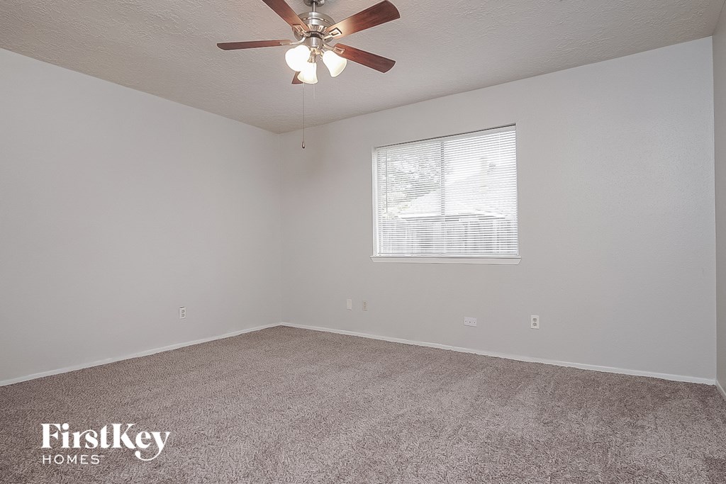 the living room of an empty house with a ceiling fan