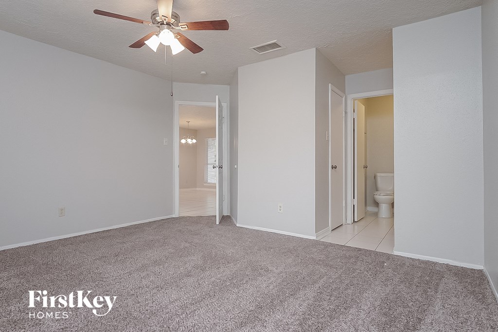 the living room of an empty house with a ceiling fan
