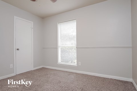 a bedroom with white walls and a window and a door