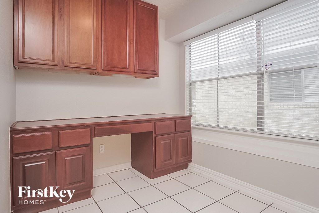 a kitchen with a desk and a window