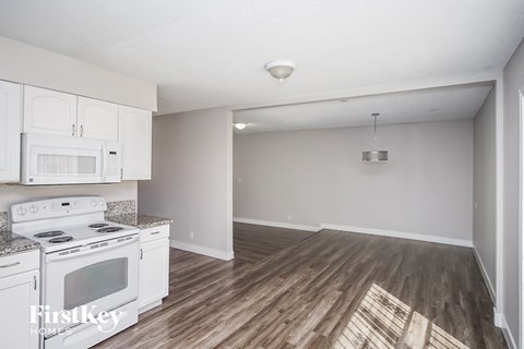 A kitchen with white cabinets and a stove top oven.