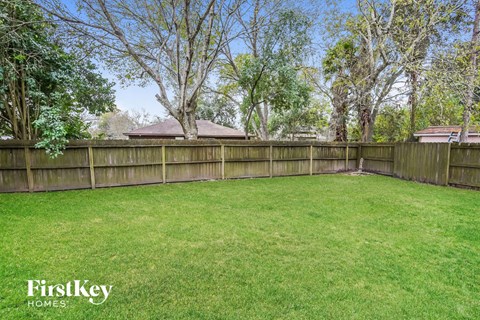 A backyard with a wooden fence and trees.