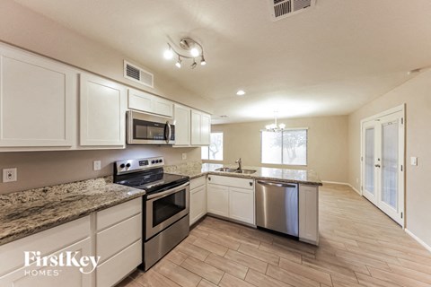 A kitchen with a granite countertop and stainless steel appliances.