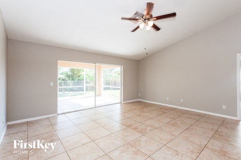 an empty living room with a ceiling fan