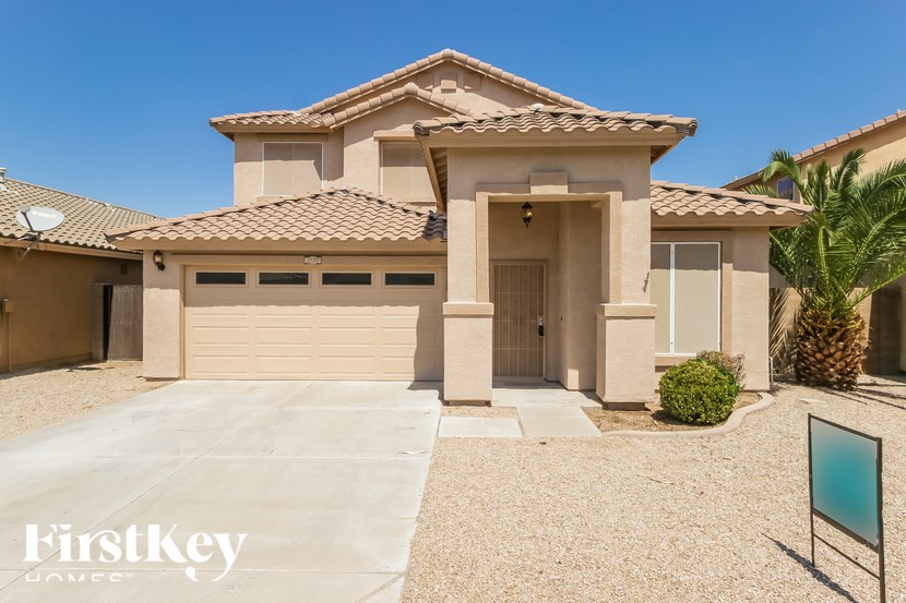 A house with a garage and a driveway in front of it.