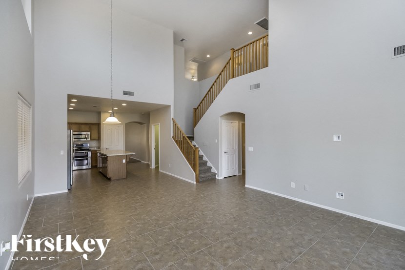 A spacious living room with a staircase leading to the upper floor.