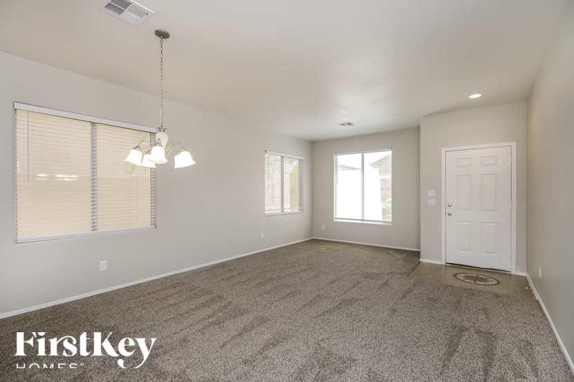 A spacious room with a carpeted floor and a white door.