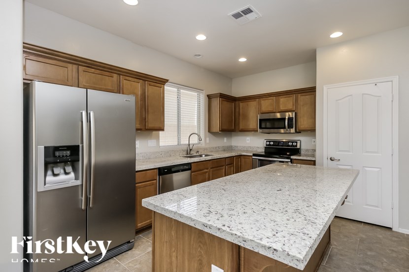A kitchen with a granite countertop and a refrigerator.